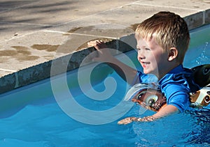 Young boy in the swimming pool with a rubber ring