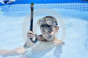 a young boy swimming in a pool with a stick
