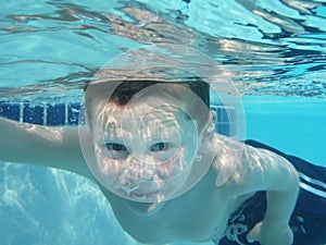 Young boy swimming underwater