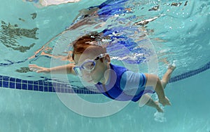 Young boy swimming underwater