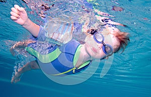 Young boy swimming underwater and holding breath