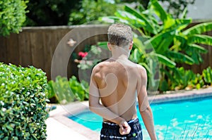 Young boy in swimsuit by pool