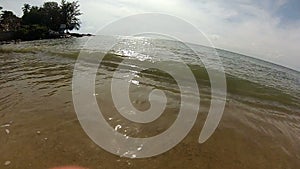 Young boy swinging on a swing over the ocean