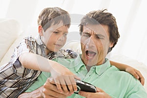 Young boy taking handheld game from man photo