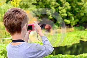 Young boy taking photos of the pond