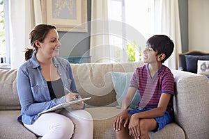 Young Boy Talking With Counselor At Home