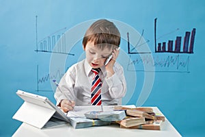 Young boy, talking on the phone, writing notes, money and tablet