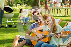 Young boy teaches playing guitar