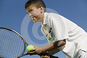 Young boy on tennis court Preparing to Serve close up low angle view photo