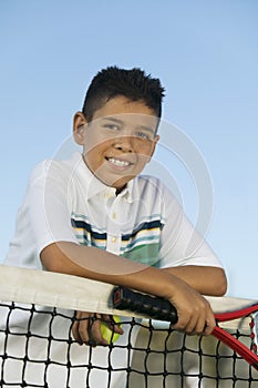 Young boy with tennis racket and ball