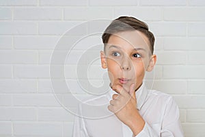 Young boy thinkin on white background looking at the side