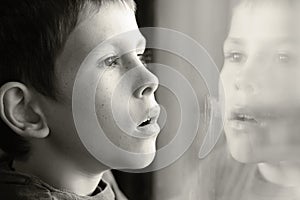 Young boy in thought with window reflection