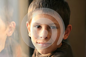 Young boy in thought with window reflection