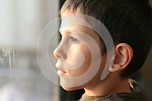 Young boy in thought with window reflection