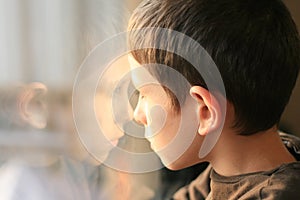 Young boy in thought with window reflection photo