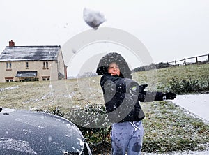 Young boy throwing a snowball outdoors