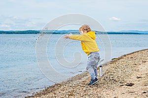 Young boy throwing stones in sea water