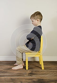 A young boy on a time out chair