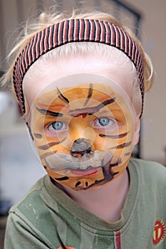 Young boy or toddler covered in Tiger face paint