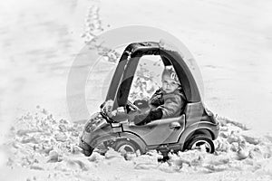 Young Boy in a Toy Car Stuck in the Snow - Black and White
