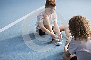 Young boy tying shoelaces