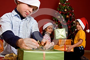 Young boy unwrapping Christmas gift