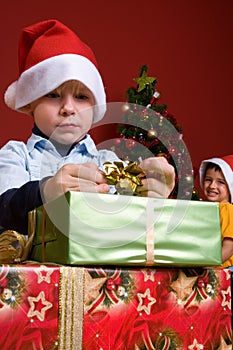Young boy unwrapping Christmas gift