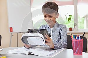 Young boy using 3d virtual reality headset at school