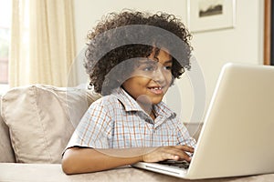 Young Boy Using Laptop At Home