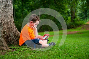 Young boy using tablet outdoors