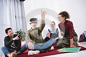 young boy in virtual reality glasses sitting on carpet