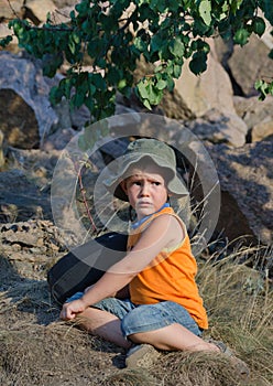 Young boy waiting alongside his rucksack