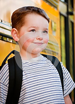 Young boy waits to board bus for school