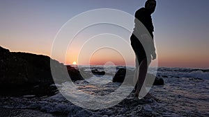 Young boy walking on the beach at sunset