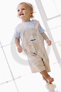 Young boy walking indoors smiling