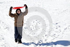 Young boy walks with tobogganing on the head on fresh snow