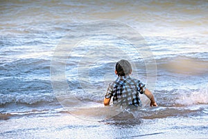 Young boy watches waves on Lake Michigan