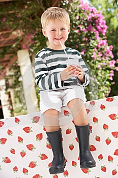 Young Boy Wearing Boots Drinking Milkshake
