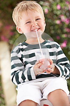 Young Boy Wearing Boots With Milkshake