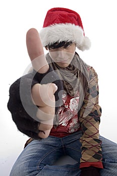 Young boy wearing christmas hat showing thumb