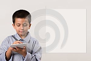 Young boy wearing his dads shirt pretending to be businessman with digital devices and pen