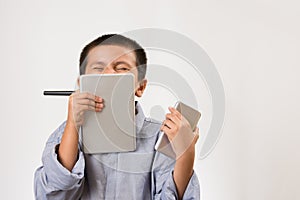 Young boy wearing his dads shirt pretending to be businessman with digital devices and pen. Childhood education, learning play