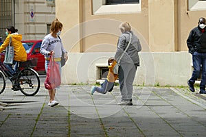 Young boy wearing protective mask can now meet again his granmother in Phase 2 after lockdown for Coronavirus pandemic