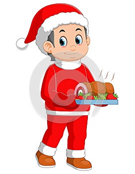 Young boy wearing santa costume showing roast beef on dish