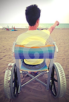 young boy on the wheelchair near the sea