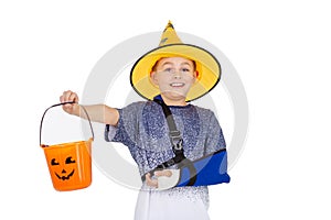 Young boy in a wizard hat and sparkly cape, smiling with Halloween bucket, ready trick-or-treating