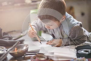 Young boy writing words in a notebook