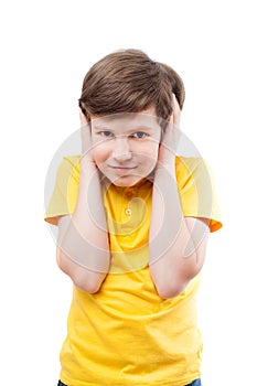 Young boy in yellow t-shirt shuts his ears by hands