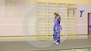 Young boy in yifu clothes for tai chi training nanquan exercise in sport club