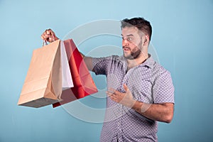 Young boy  young boy doing shopping with paper bags blue background